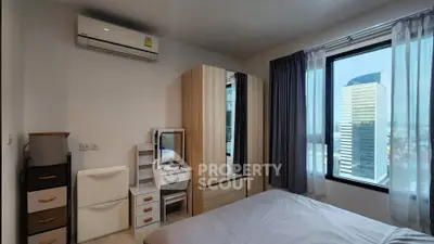 Modern bedroom with city view, featuring sleek furniture and ample natural light.