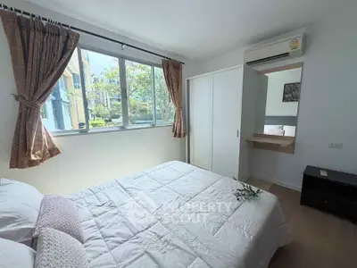 Bright and cozy bedroom with large window and modern furnishings in a stylish apartment.