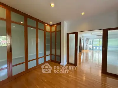 Spacious interior with elegant wooden flooring and glass-paneled doors, perfect for modern living.