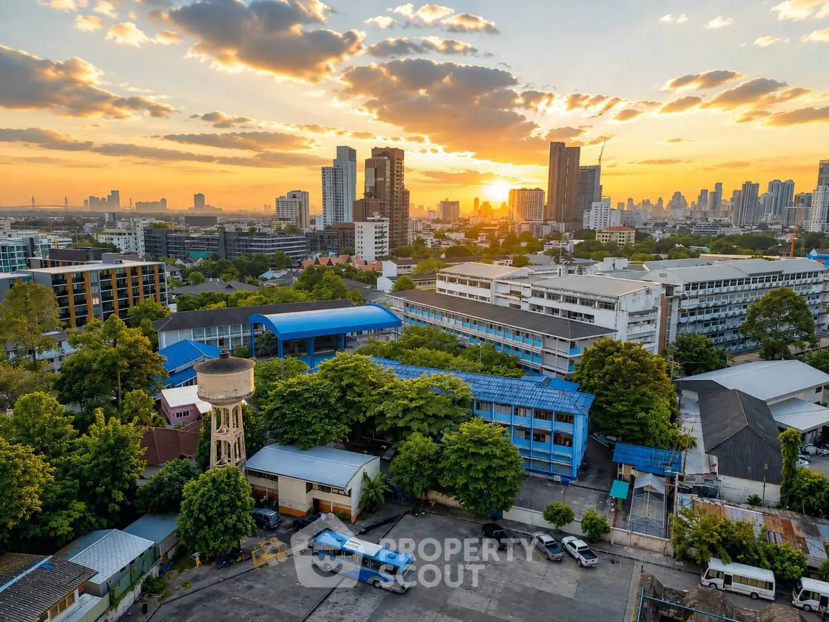 Stunning cityscape view with vibrant sunset over urban skyline and lush greenery, showcasing prime real estate location.