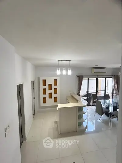 Modern open-plan living area with dining space and stylish lighting