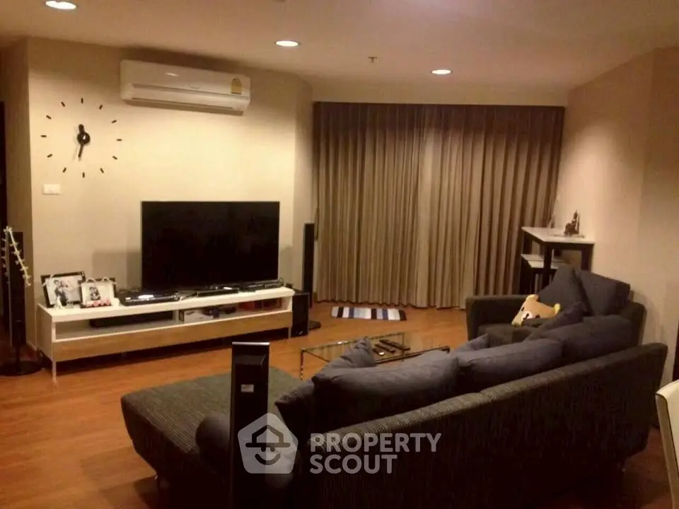 Spacious living room with modern decor and large TV, perfect for relaxation and entertainment.