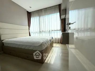 Modern bedroom with large window and stylish decor, featuring a comfortable bed and ample natural light.