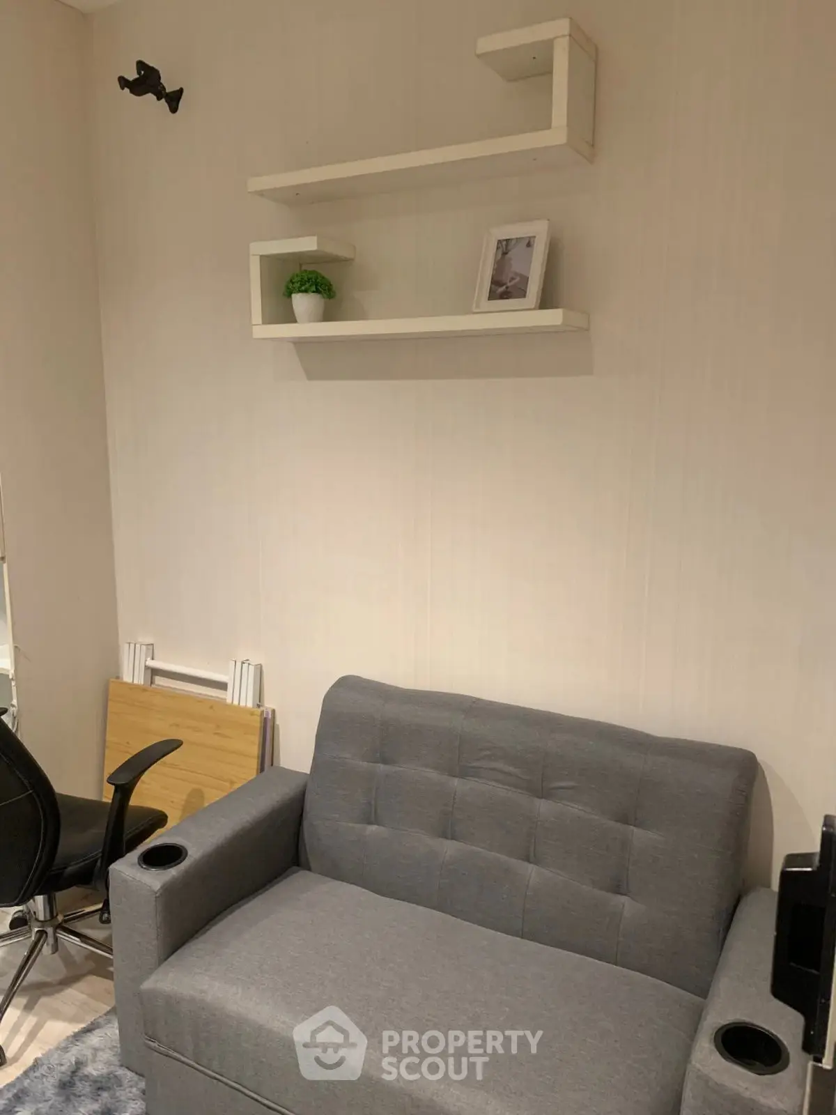 Cozy living room with modern gray sofa and minimalist wall shelves