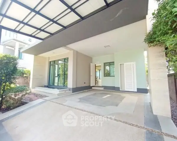 Modern house exterior with covered parking and lush greenery