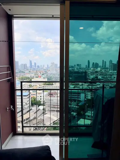 Stunning cityscape view from a modern apartment balcony with glass doors.
