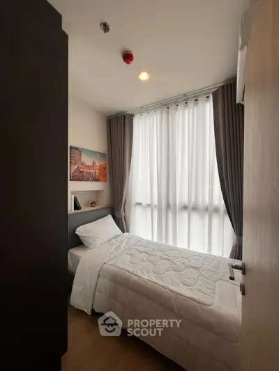 Cozy single bedroom with large window and modern decor