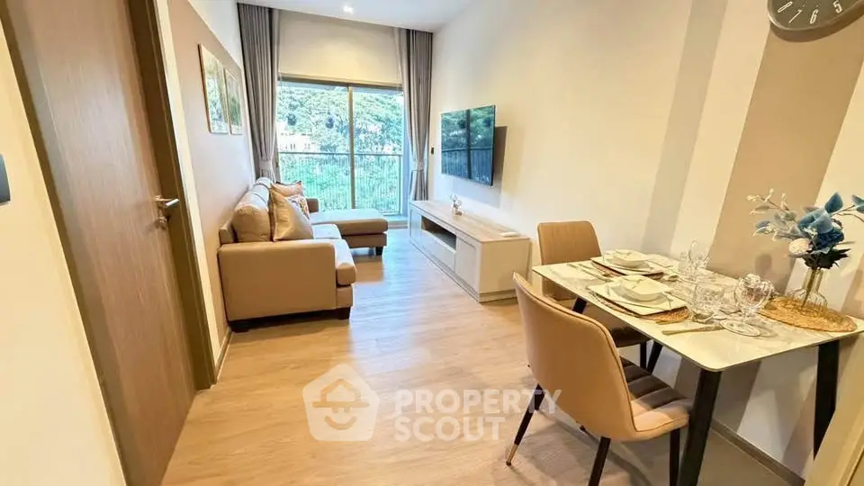 Modern living room with dining area, featuring stylish furniture and large window with a view.