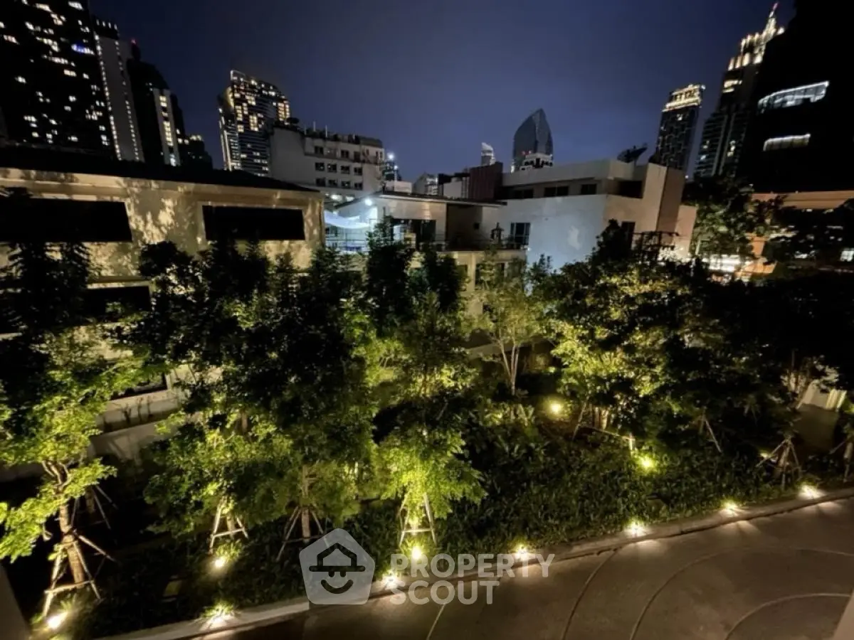 Stunning night view of modern urban residential complex with lush greenery and city skyline.