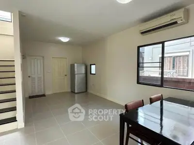 Spacious open-plan living area with modern dining set and sleek appliances, perfect for contemporary living.