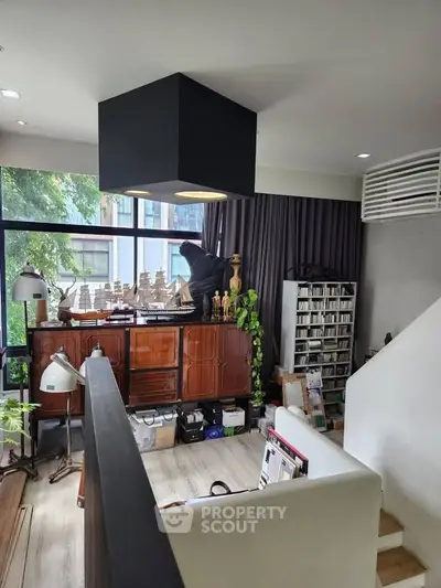 Stylish living room with modern decor and large window view, perfect for urban living.