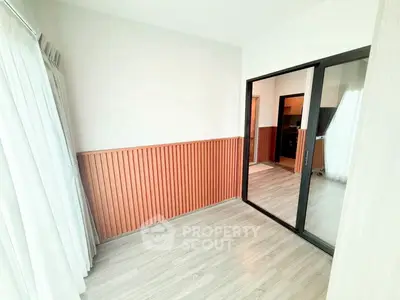 Bright room with wooden paneling and large mirror, ideal for versatile use