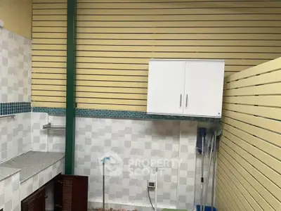 Modern utility area with sleek storage and tiled walls