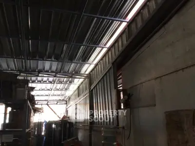 Spacious industrial warehouse with high metal ceilings and ample storage space.