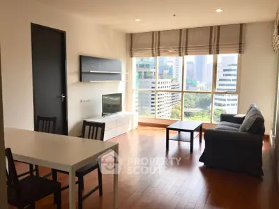 Spacious living room with city view, modern furniture, and natural light in a high-rise apartment.