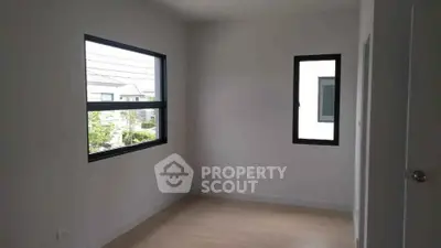 Bright empty room with large windows and wooden flooring