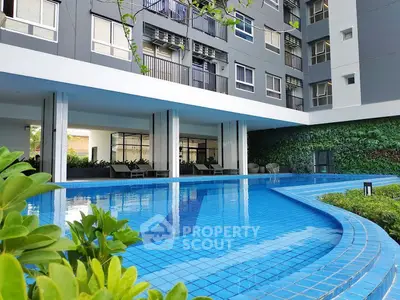 Modern apartment building with a luxurious outdoor pool and lush greenery.