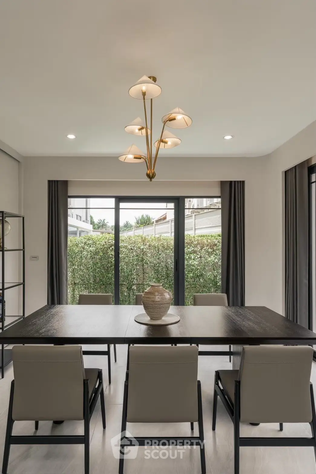 Elegant dining room with modern chandelier and garden view, perfect for stylish entertaining.