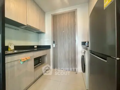 Modern kitchen with sleek appliances and wooden cabinetry in a stylish apartment.