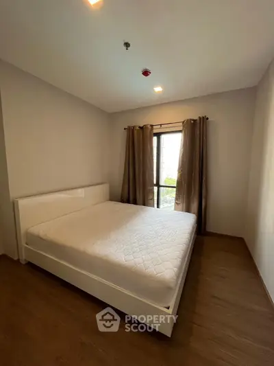 Spacious bedroom with large window and modern minimalist design