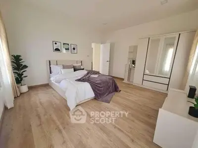 Spacious modern bedroom with wooden flooring and stylish decor