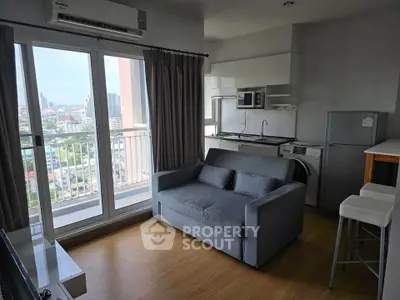 Modern apartment with city view, featuring cozy living area and compact kitchen.