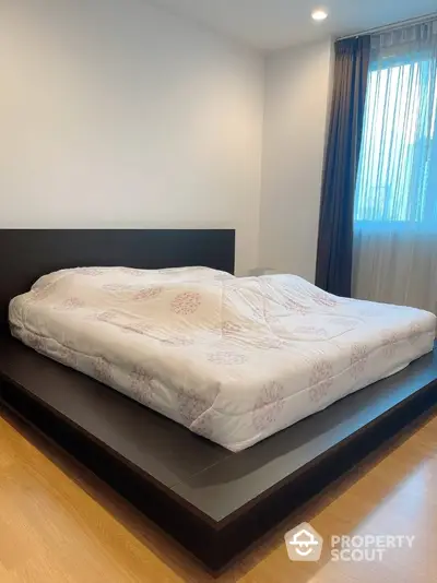 Modern bedroom with platform bed and natural light from large window