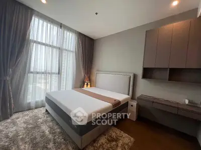 Modern bedroom with large window and stylish furniture in a high-rise apartment.