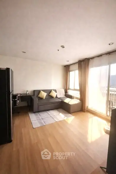 Spacious living room with natural light and modern decor in a stylish apartment.