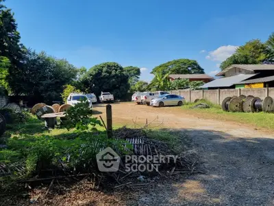 Spacious outdoor parking area with multiple cars and lush greenery, ideal for residential or commercial use.