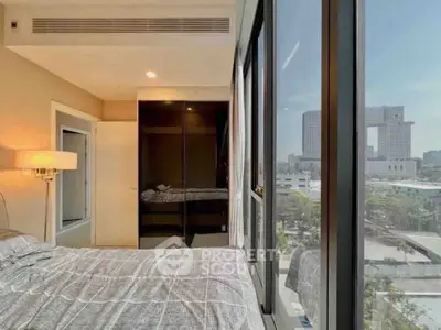 Modern bedroom with large windows offering a stunning city view, featuring sleek design and ample natural light.