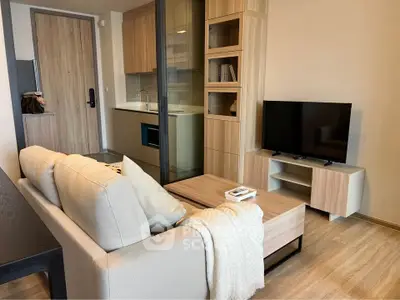 Modern living room with cozy sofa, TV, and stylish wooden furniture in open layout apartment.