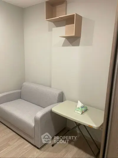 Cozy small living room with modern sofa and wall-mounted shelves