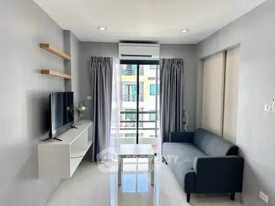 Modern living room with sleek furniture and large window offering natural light.