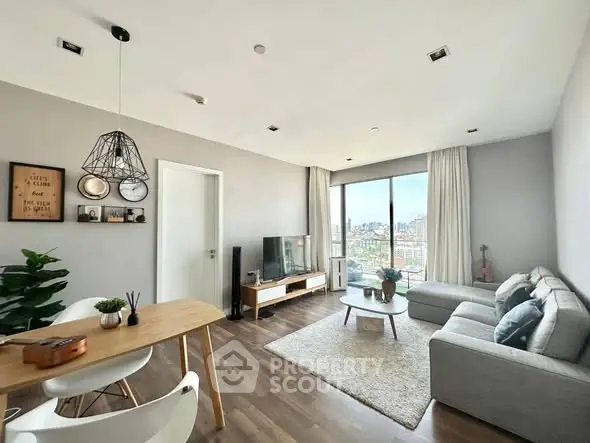 Modern living room with city view, stylish decor, and cozy seating area.