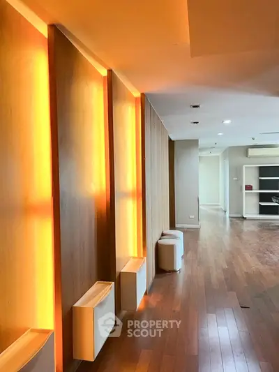 Spacious modern living room with warm wooden flooring and ambient lighting