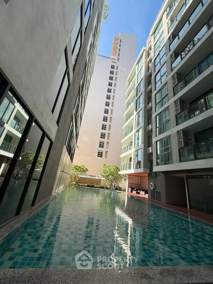 Modern apartment complex with a stunning outdoor pool and sleek architectural design.