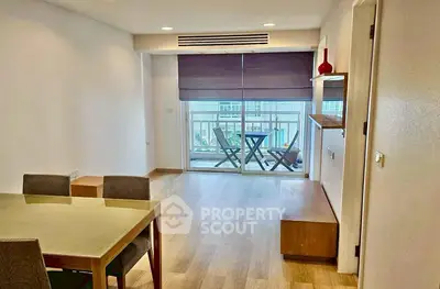 Spacious living room with balcony access and modern dining area in a bright apartment.