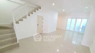 Spacious modern living room with staircase and large windows