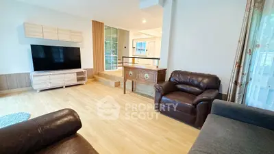 Spacious living room with modern furniture and large TV, perfect for relaxation.