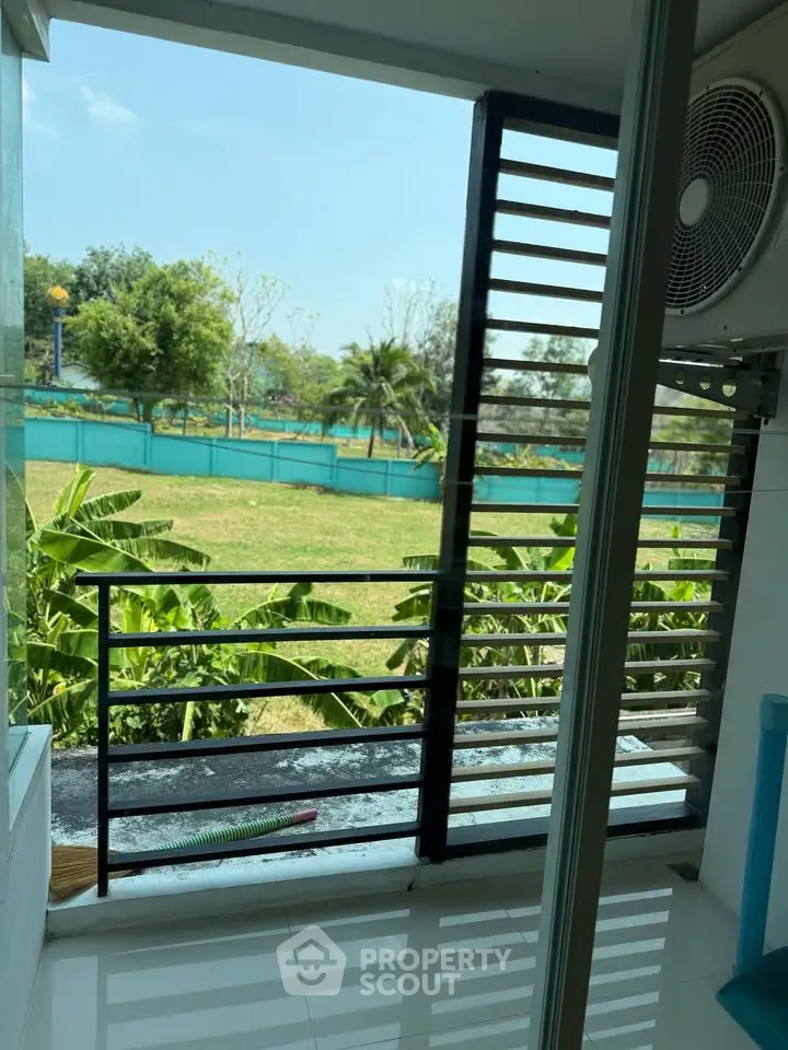 Charming balcony with lush garden view, perfect for relaxation and enjoying nature.