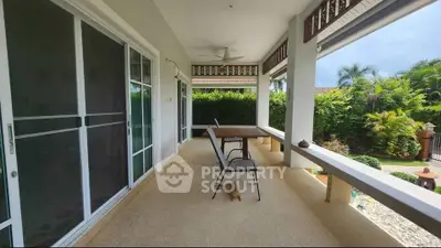 Spacious covered patio with garden view, perfect for outdoor relaxation and entertainment.