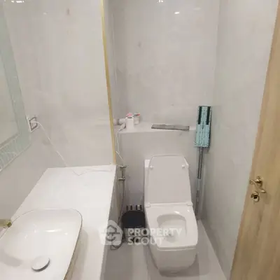 Modern bathroom with sleek white fixtures and minimalist design.