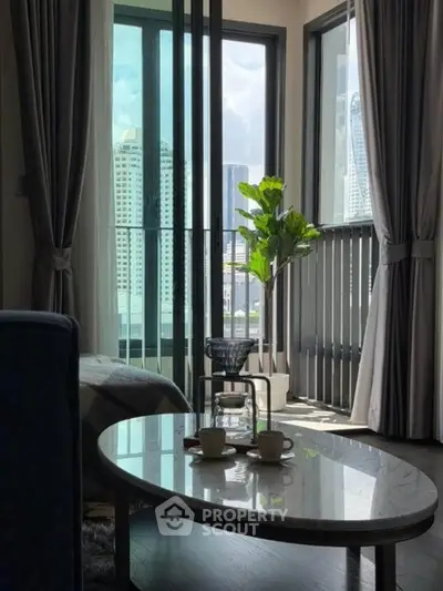 Modern living room with large windows and city view, featuring stylish decor and natural light.