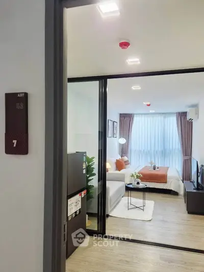 Modern living room with stylish decor and large window in a cozy apartment.
