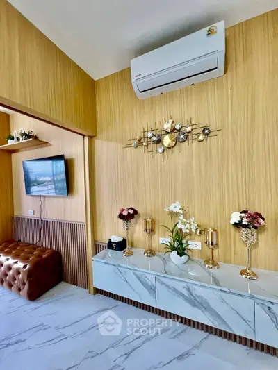 Stylish living room with modern decor and air conditioning, featuring elegant wall art and marble flooring.