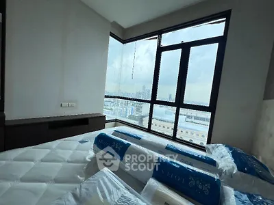 Spacious bedroom with large windows offering stunning city views.