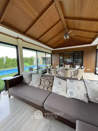 Luxurious living room with pool view and elegant wooden ceiling design