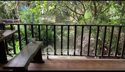 Charming rustic balcony overlooking lush garden and serene waterway, perfect for nature lovers.
