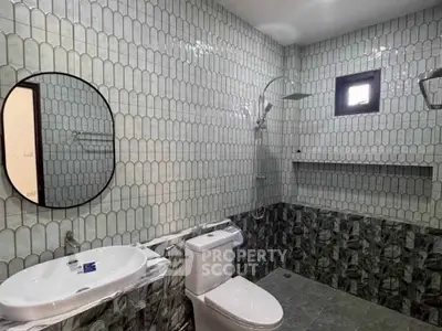 Modern bathroom with stylish tile design and round mirror
